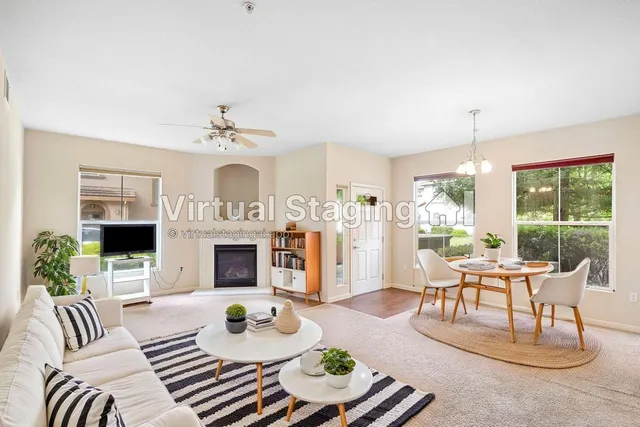 a living room with furniture fireplace and a large window