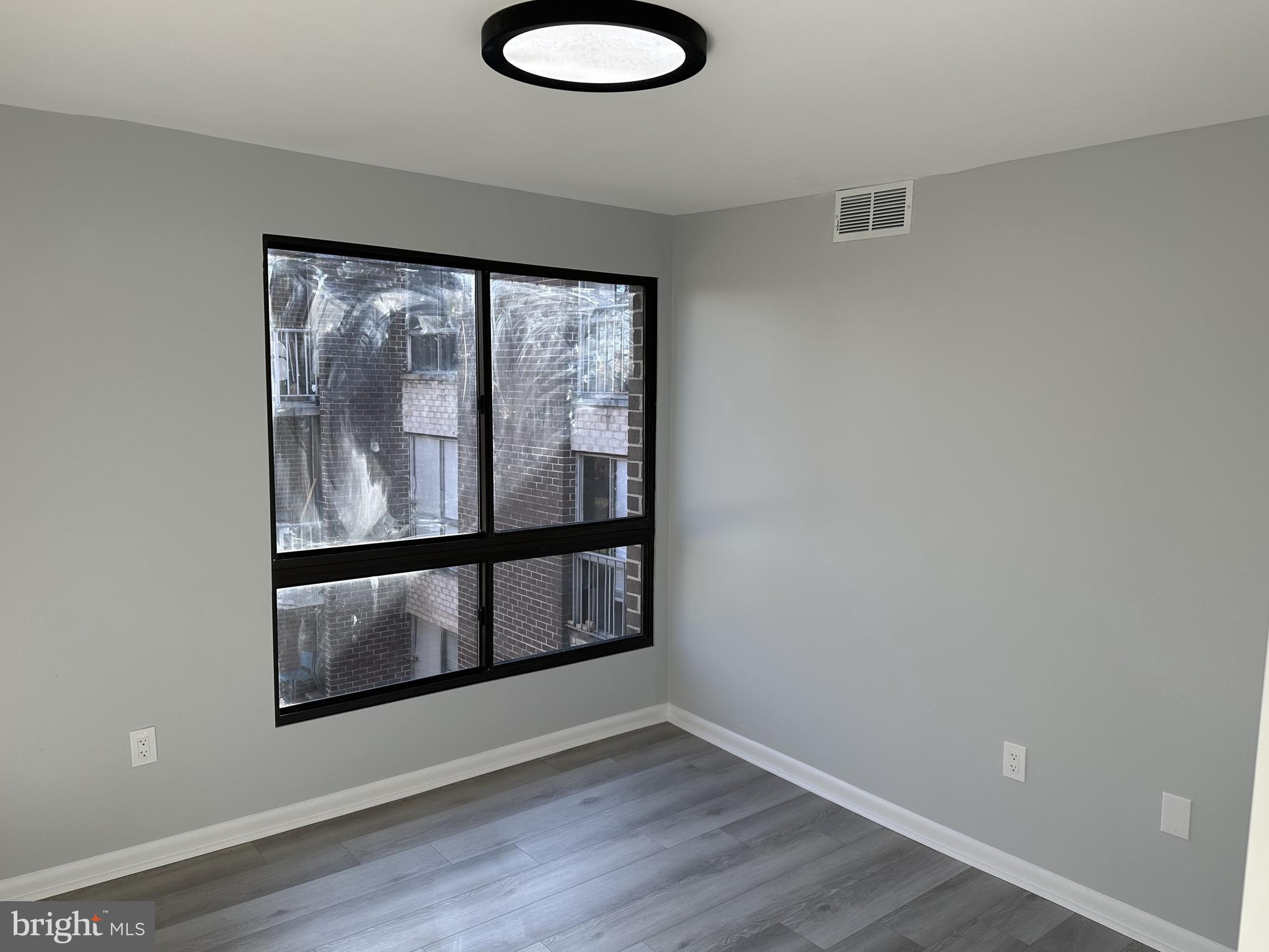 7967 Riggs Road, Unit 796710 Hyattsville, MD 20783 - Photo 10 of 11 wooden floor in an empty room with a window