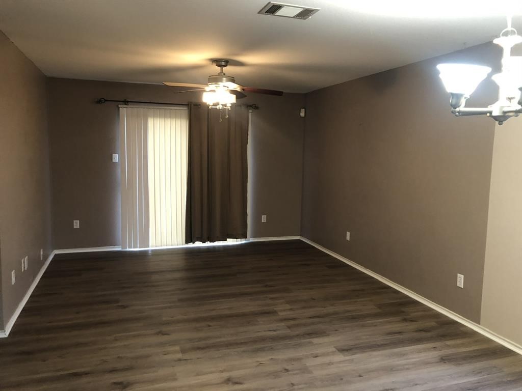 211 Woodley Road Leander, TX 78641 - Photo 14 of 15 Rich wood-look flooring anchors this open living space featuring a sliding glass door.