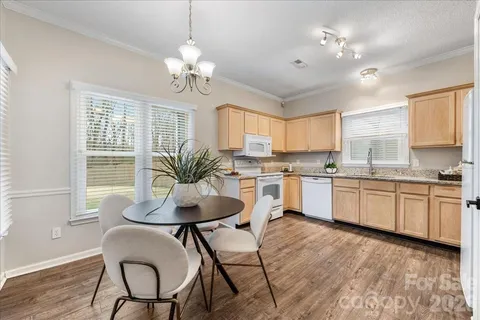 a kitchen with a dining table chairs sink and cabinets