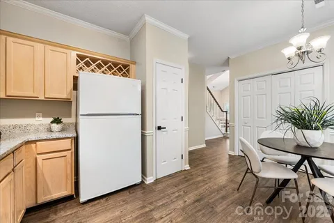a kitchen with a refrigerator and white cabinets