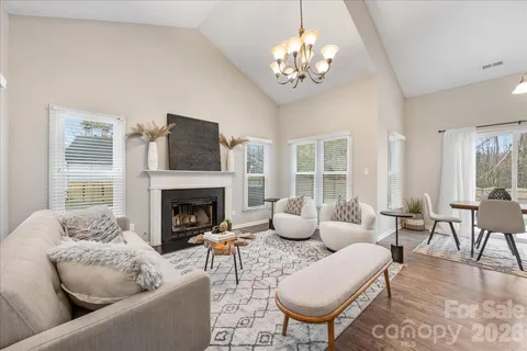 a living room with furniture a chandelier and a fireplace