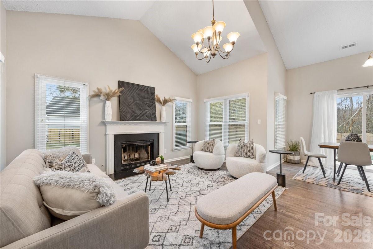 7800 Trotter Road Charlotte, NC 28216 - Photo 8 of 46 a living room with furniture a chandelier and a fireplace