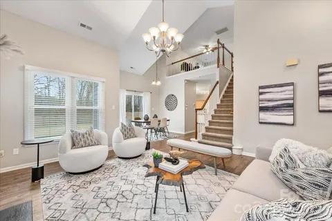 a living room with furniture and a chandelier