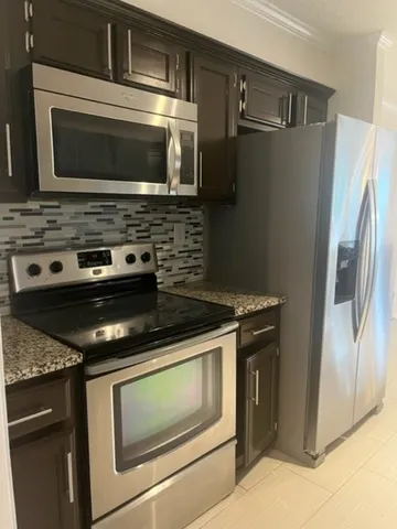 a kitchen with granite countertop cabinets and steel stainless steel appliances