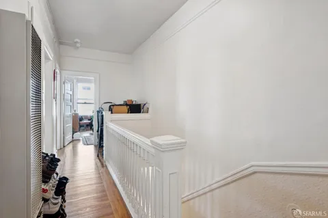 a view of a hallway to a livingroom and a staircase