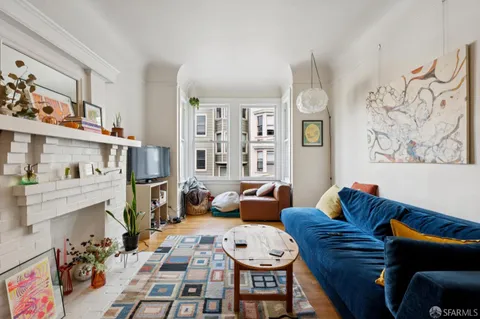 a living room with furniture a rug and a painting on the wall