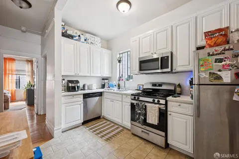 a kitchen with white cabinets and appliances