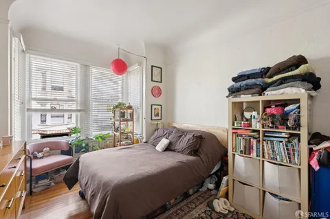 a bedroom with a bed and a large window with the outer view