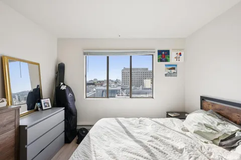 a bedroom with a bed a large window with the outer view