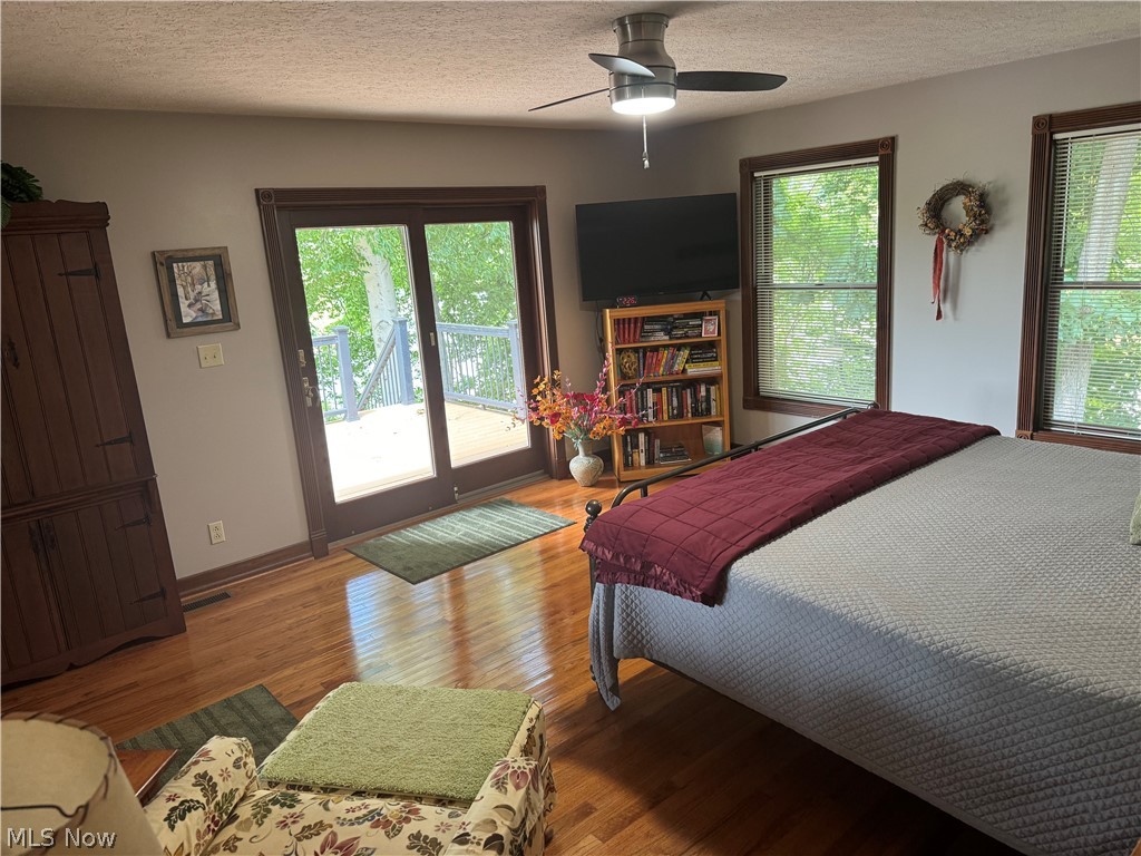 382 Riverview Acres Road Washington, WV 26181 - Photo 10 of 24 Bedroom with access to outside, a textured ceiling, ceiling fan, and hardwood / wood-style floors