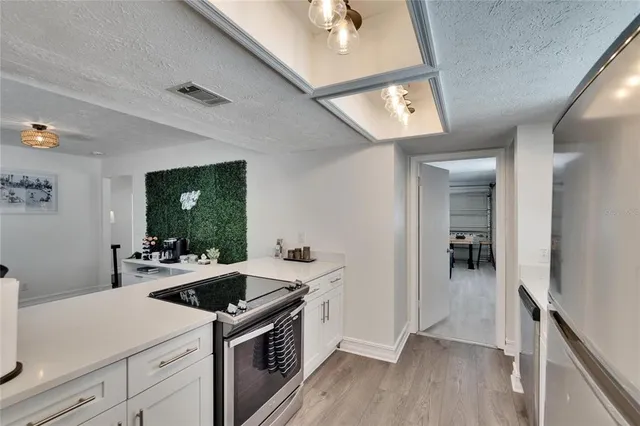 a kitchen with white cabinets and refrigerator