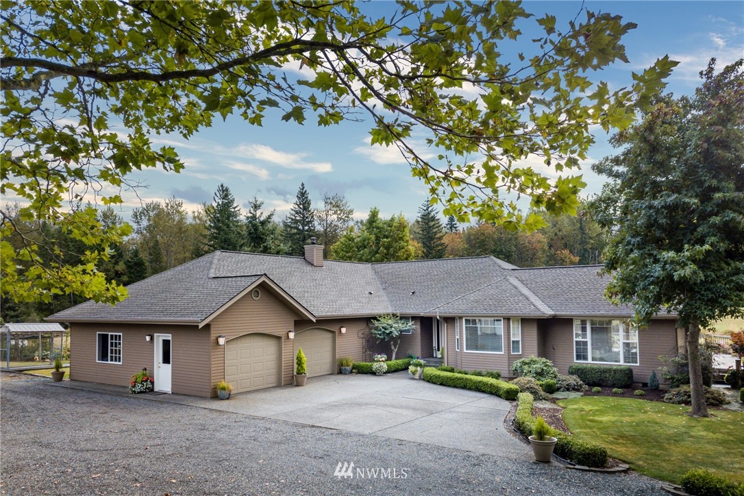 5044 Mission Road Bellingham, WA 98226 - Photo 1 of 40 a view of a yard in front of a house with large tree