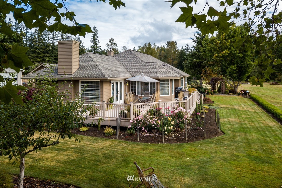 5044 Mission Road Bellingham, WA 98226 - Photo 29 of 40 a view of a house with swimming pool lawn chairs and a yard tree s