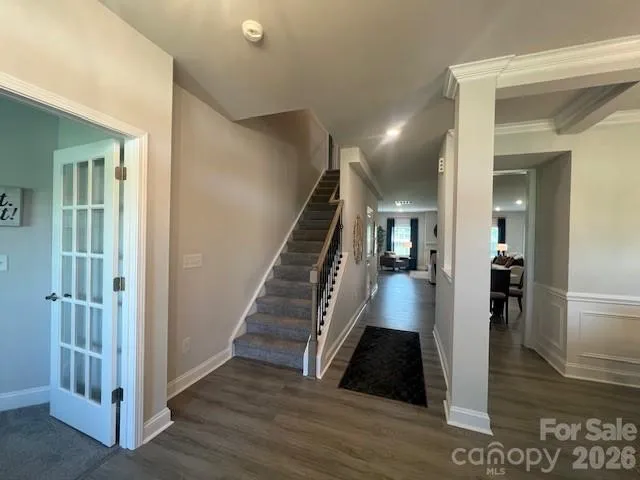 a living room with furniture wooden floor and a kitchen view