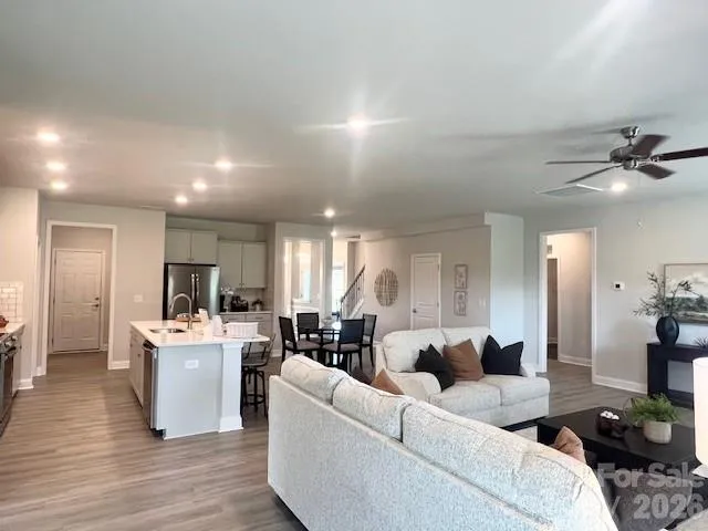 a living room with stainless steel appliances kitchen island granite countertop furniture wooden floor and a kitchen view