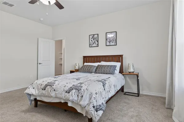 a spacious bedroom with a bed and a chandelier