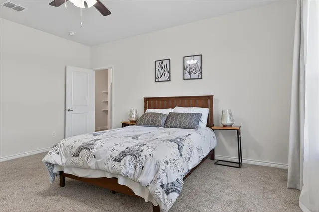 a spacious bedroom with a bed and a chandelier