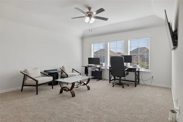 a living room with furniture a flat screen tv and a window
