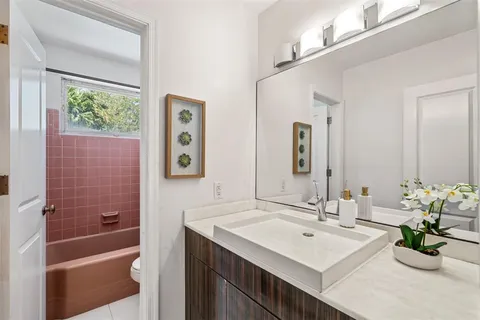 a bathroom with a bathtub a sink and a mirror