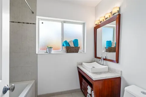 a bathroom with a sink mirror vanity and toilet