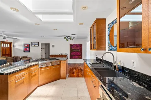 a large kitchen with granite countertop a sink and a stove