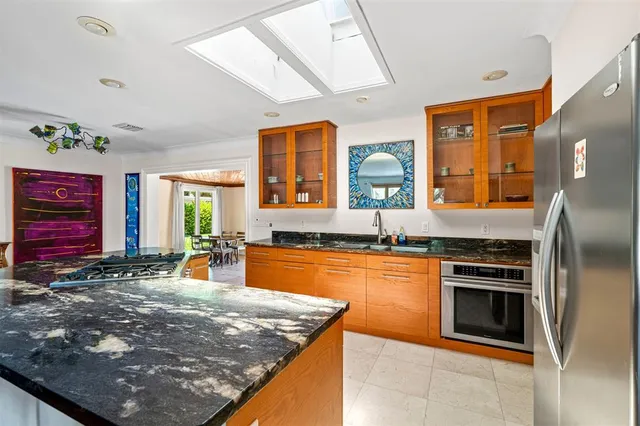 a kitchen with stainless steel appliances granite countertop a sink stove and refrigerator