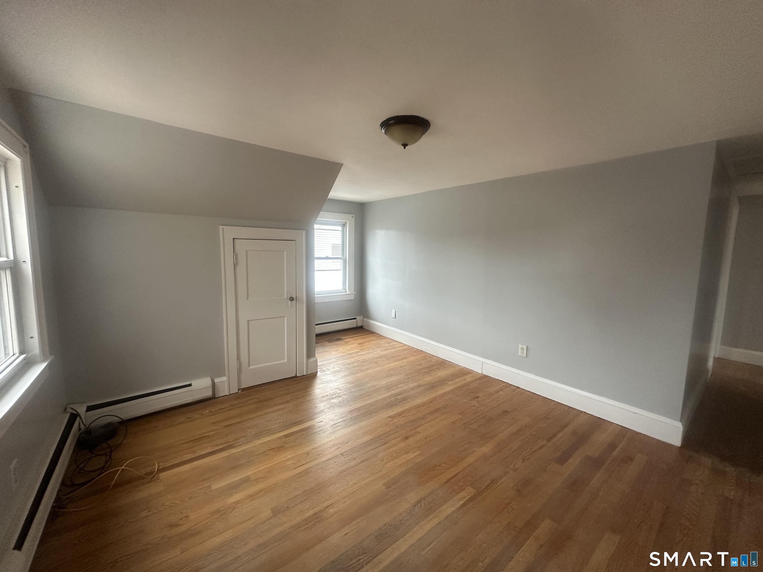 33 Emory Court Bristol, CT 06010 - Photo 7 of 11 an empty room with wooden floor and windows