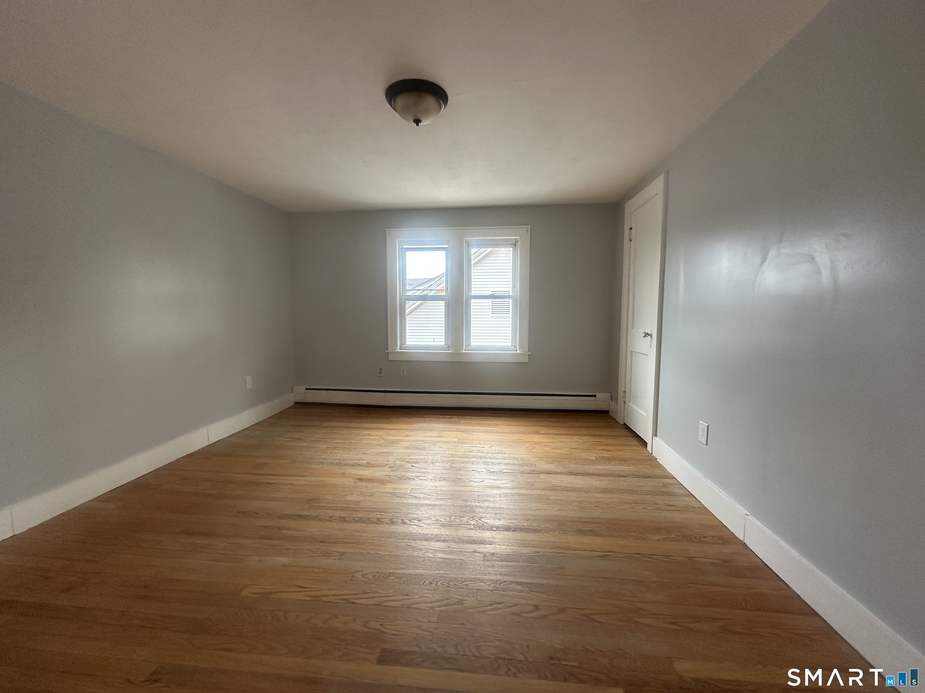 33 Emory Court Bristol, CT 06010 - Photo 8 of 11 an empty room with wooden floor and windows
