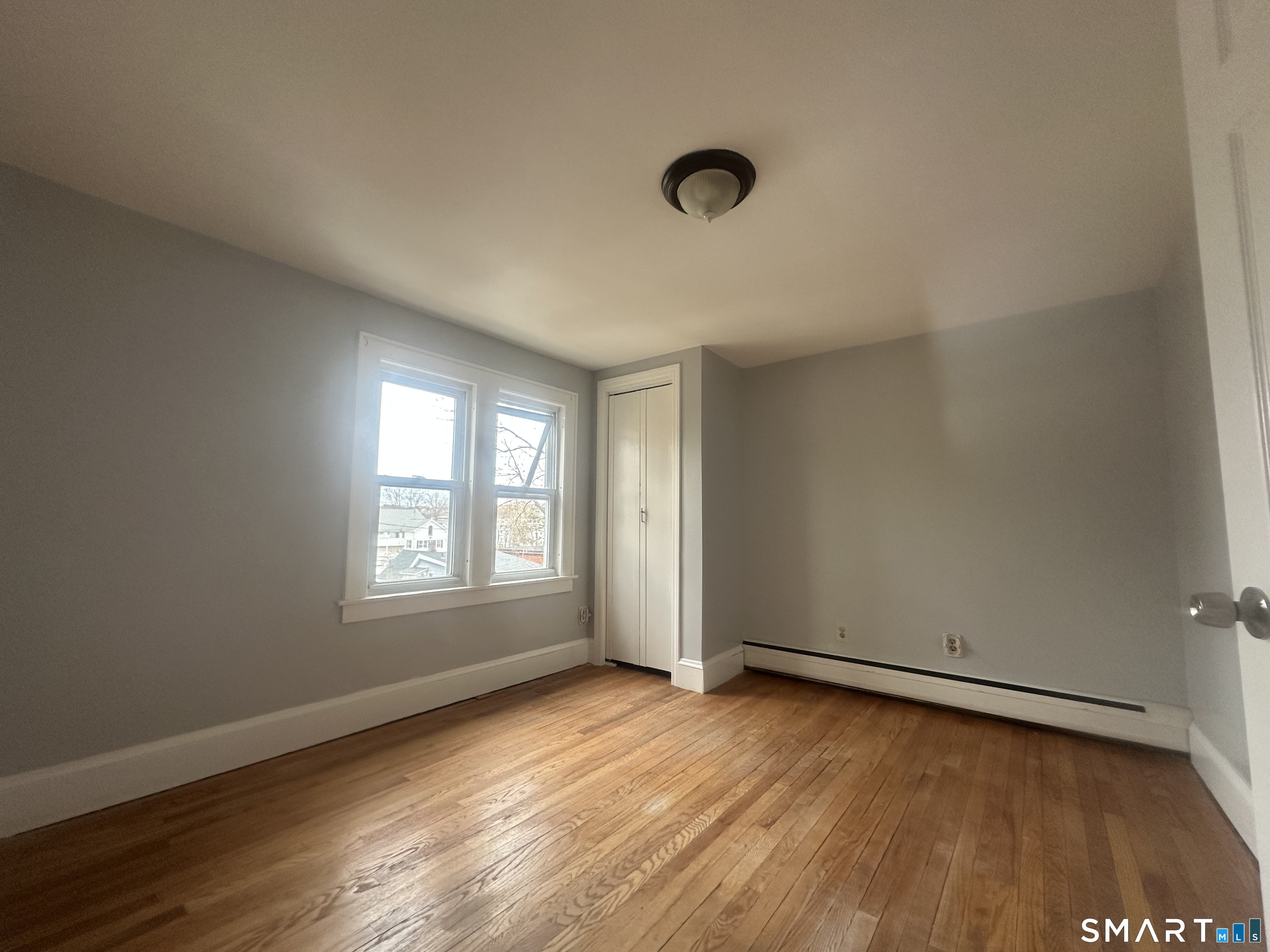 33 Emory Court Bristol, CT 06010 - Photo 9 of 11 an empty room with wooden floor and windows