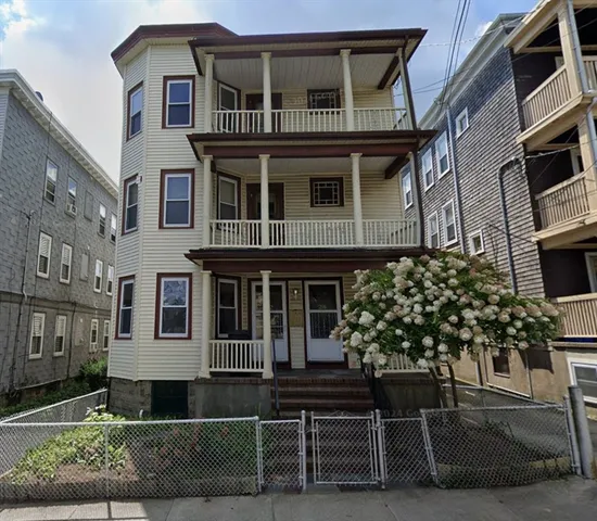 a front view of a house with a tree