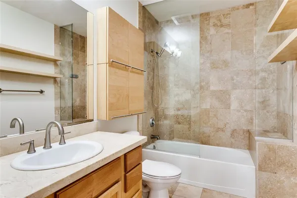 a bathroom with a sink toilet vanity and shower