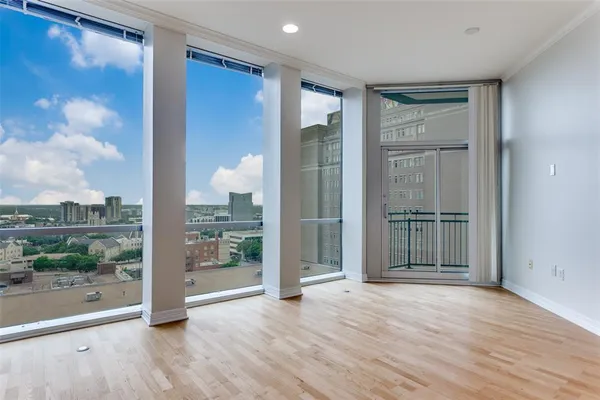 a view of a big room with wooden floor and windows