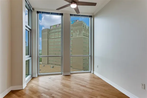 an empty room with wooden floor and a hallway