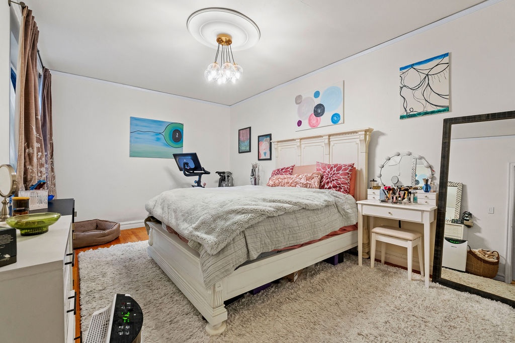 225 East 74th Street, Unit 3F Manhattan, NY 10021 - Photo 6 of 11 a bedroom with a bed and a chandelier