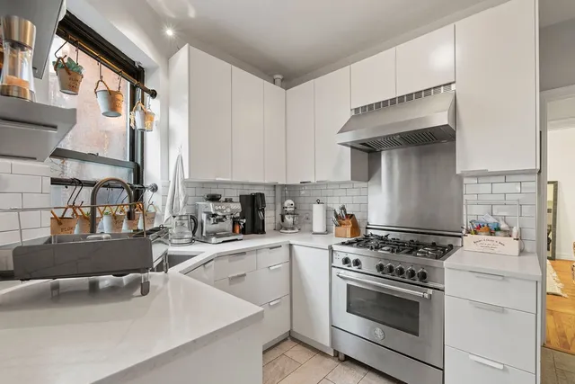 a kitchen with a stove a sink and a cabinets