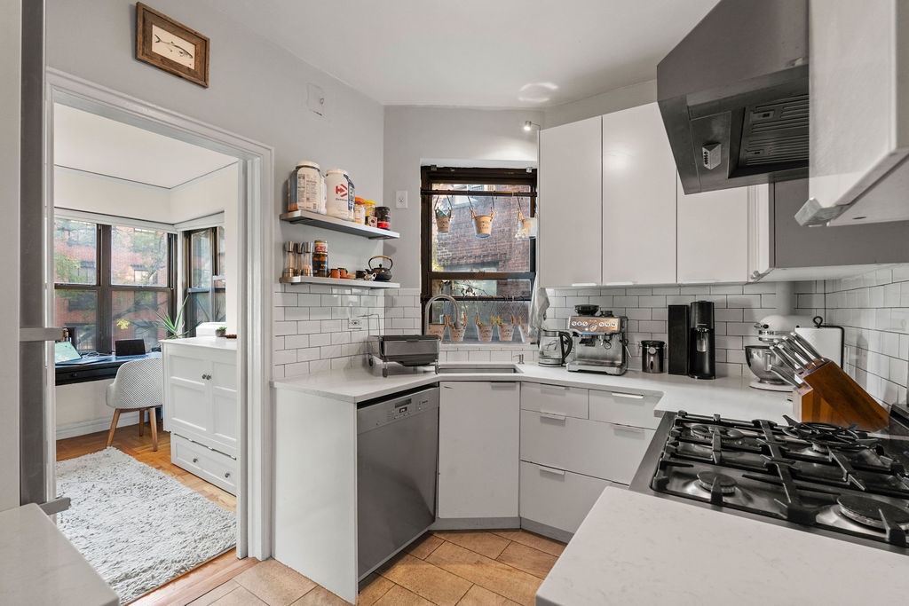 225 East 74th Street, Unit 3F Manhattan, NY 10021 - Photo 9 of 11 a kitchen with stainless steel appliances a stove a sink and a refrigerator