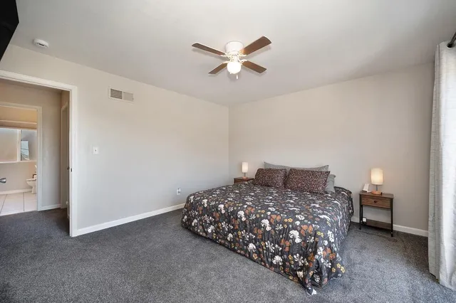 a bedroom with a bed and a ceiling fan