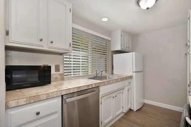a kitchen with stainless steel appliances white cabinets and a granite counter tops
