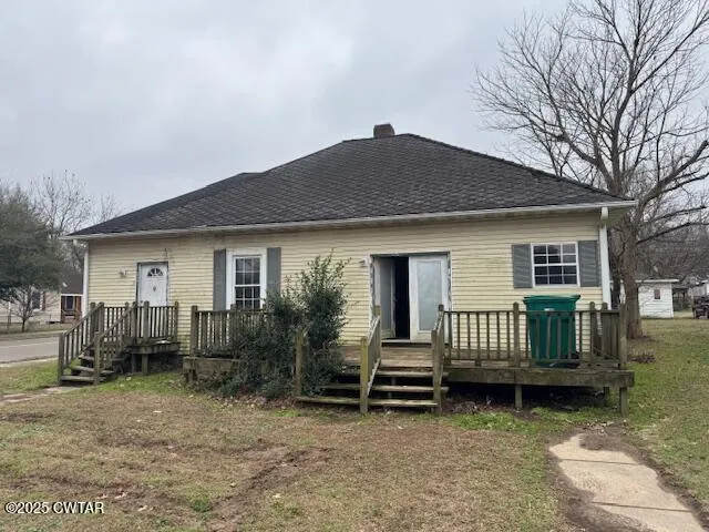 a view of a house with wooden deck and a yard