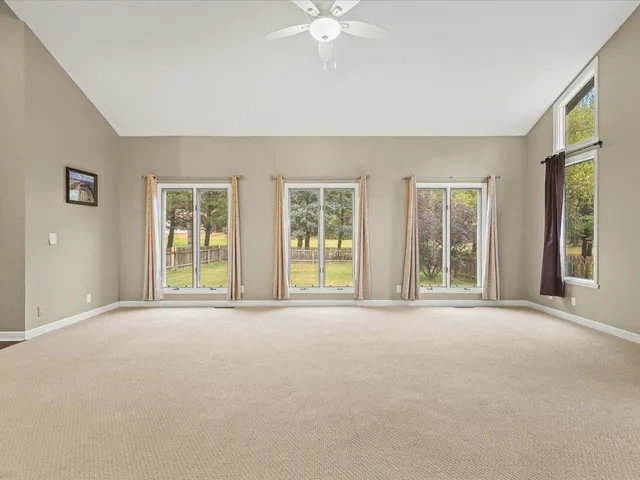a view of a big room with wooden floor and windows