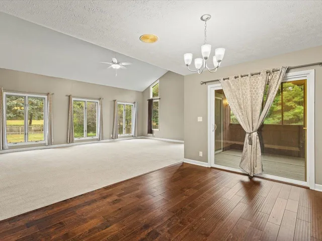 a view of an empty room with a fireplace and a window