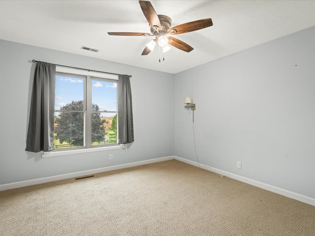9104 East Weber Road Ridott, IL 61067 - Photo 33 of 96 an empty room with a window and a ceiling fan
