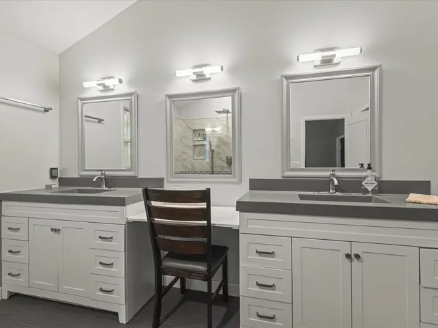 a view of an empty room with a window and kitchen view