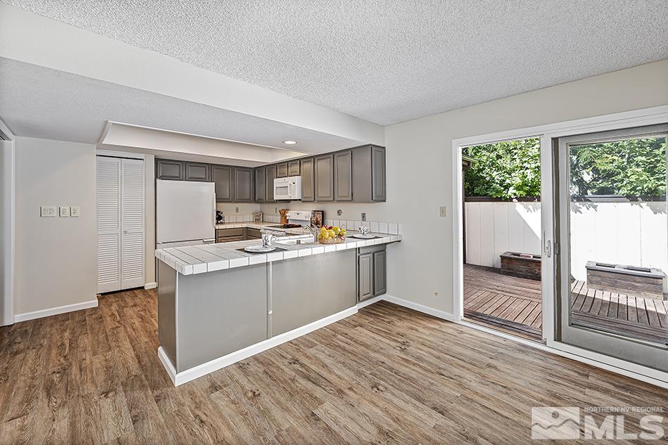 1600 Foster Drive Reno, NV 89509 - Photo 11 of 22 a kitchen with wooden floors and white cabinets