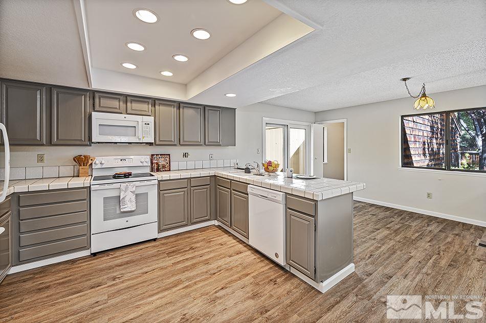1600 Foster Drive Reno, NV 89509 - Photo 8 of 22 a kitchen with granite countertop white cabinets and white appliances