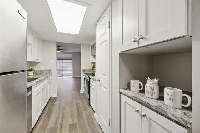 a kitchen with granite countertop a sink stove and cabinets