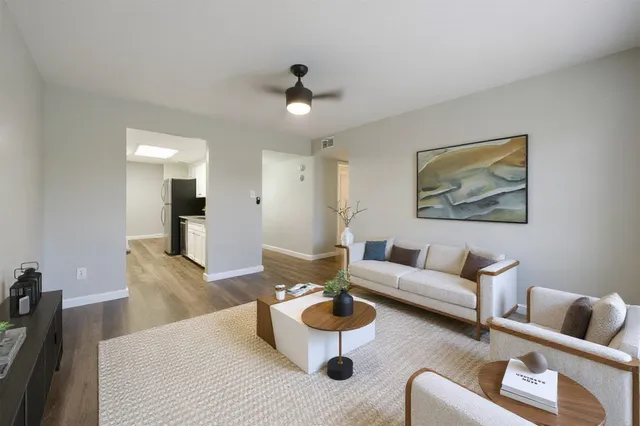 a living room with furniture and a wooden floor