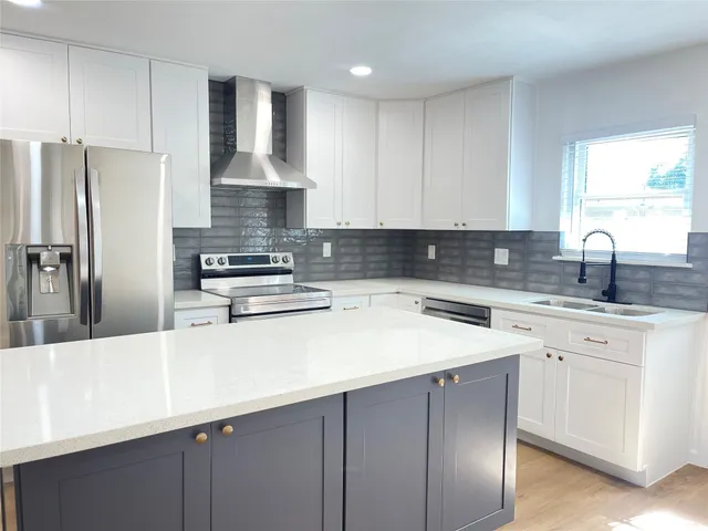 a kitchen with stainless steel appliances a sink stove and refrigerator