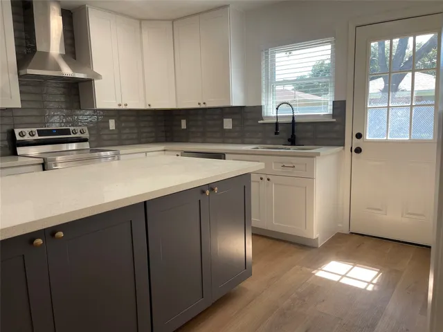 a kitchen with stainless steel appliances granite countertop a sink a stove and a granite counter tops